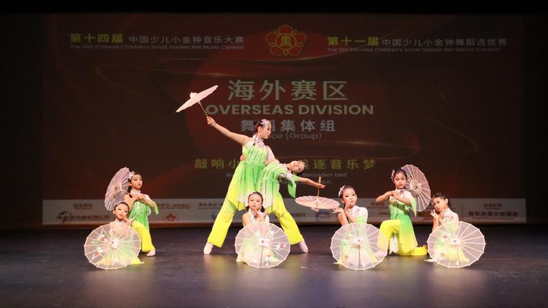 Young YiYe dancers in green with parasols at the Small Golden Bell contest, overseas division